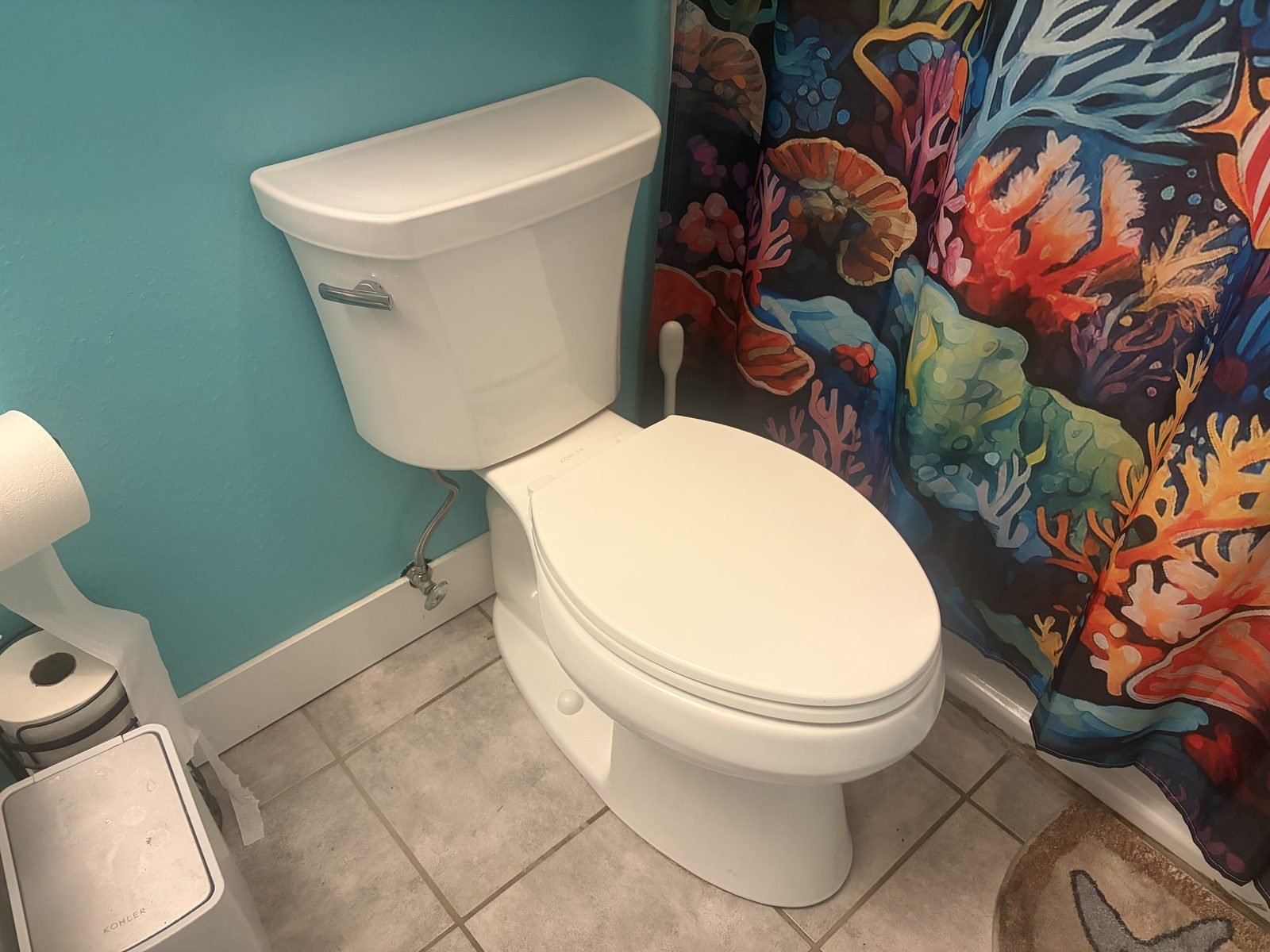 Newly installed white two-piece toilet in a West Richland bathroom, set on tile with a new braided supply line connected to the shutoff valve.